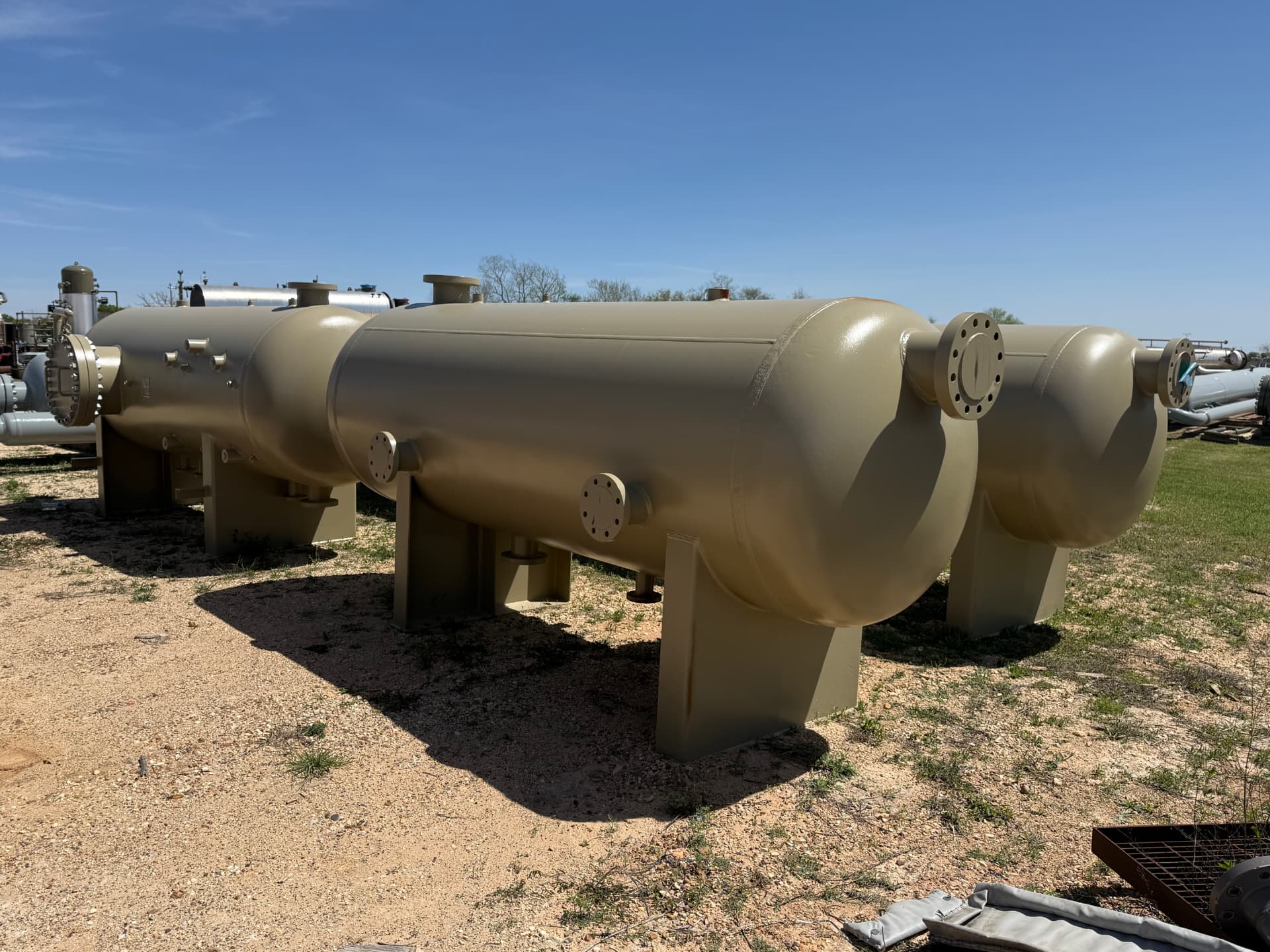 Pair of tan horizontal separator vessels in yard